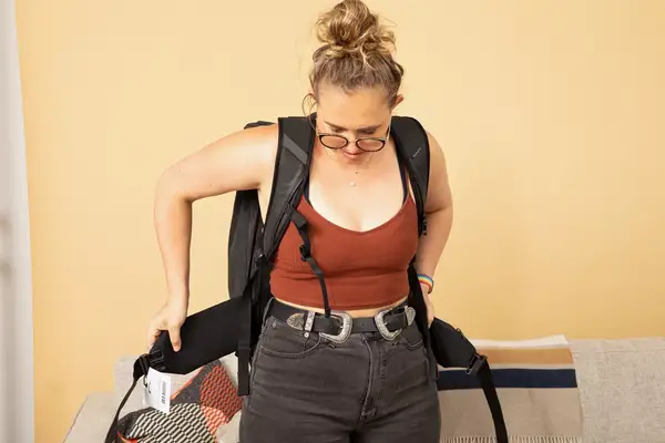 Hands putting shoes inside the Matein Travel Backpack 40L