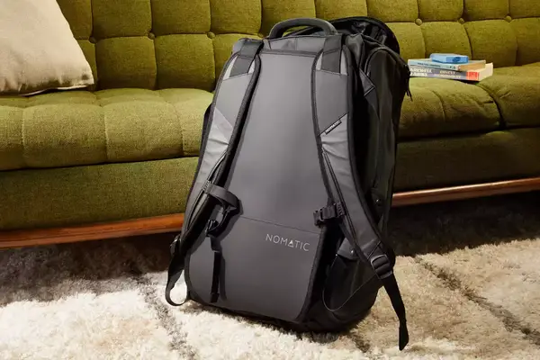 Hands putting a laptop in the Matein Travel Backpack 40L