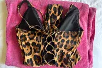 A TA3 Brazilian Plungey Swimsuit with laced details placed on a pink towel