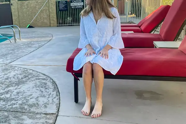 Woman sits by a pool wearing a Tommy Bahama Cotton Clip Jacquard Cover-up Shirt Dress
