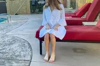 Woman sits by a pool wearing a Tommy Bahama Cotton Clip Jacquard Cover-up Shirt Dress