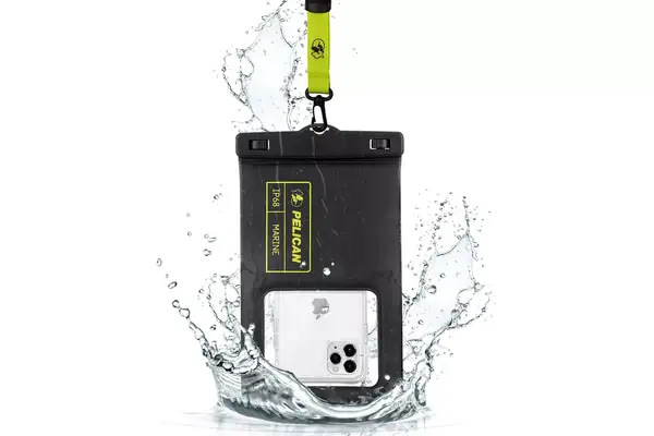 A person in a patterned dress with a Gaiatop Portable Handheld Folding Fan, standing near a railing overlooking a scenic cityscape with greenery and buildings