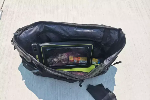 The Case-Mate Pelican Marine IP68 Waterproof Phone Pouch in a bag resting on concrete