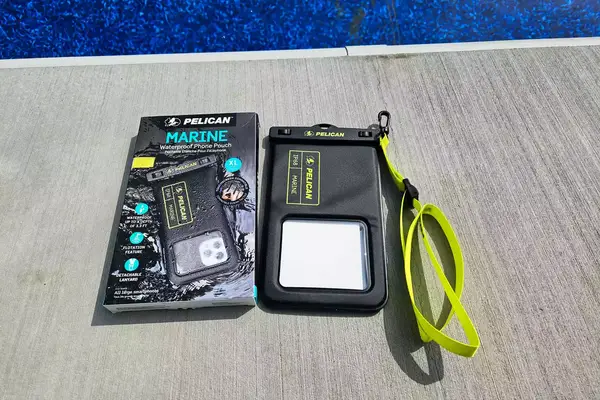 The Case-Mate Pelican Marine IP68 Waterproof Phone Pouch next to its box by pool