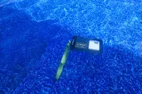 A phone in the Case-Mate Pelican Marine IP68 Waterproof Phone Pouch submerged in a pool
