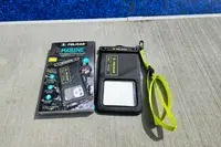 The Case-Mate Pelican Marine IP68 Waterproof Phone Pouch next to its box by pool