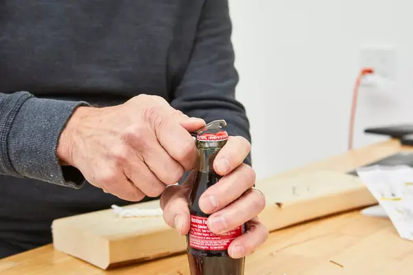 Topeak Mini 18+ Multi-Tool is being used to open a bottle cap