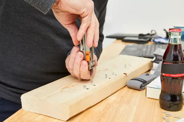 Leatherman Free P4 Multi-Tool is being used to fix a nail on wooden plank