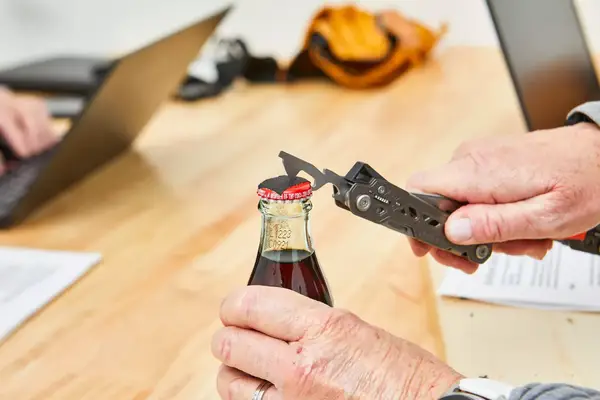 Gerber Gear Dime Multi-Tool is being used to open a bottle cap