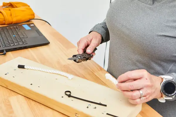 Gerber Gear Dime Multi-Tool is being used to cut the rope