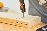 Gerber Gear Dime Multi-Tool is used to fix nail on wooden plank