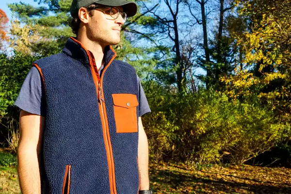 A person wears the Fjallraven Men’s Vardag Pile Fleece Vest outside