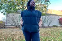 A person wears the Alo Incline Puffer Vest outside