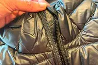 A person holds up a zipper on the Columbia Women