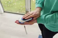 Someone holds a pair of sunglasses