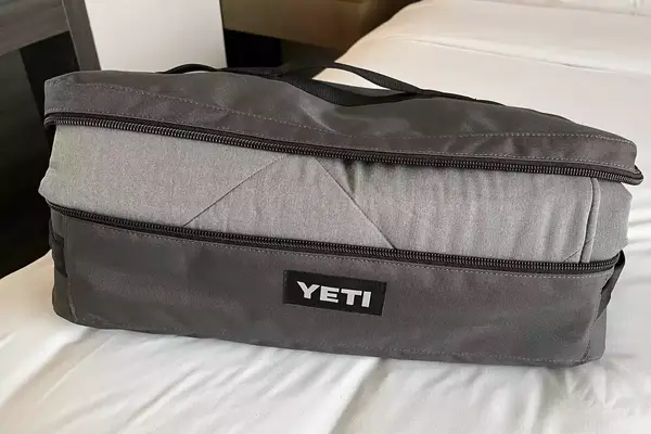 A Yeti Lowlands Blanket in its bag displayed on a bed