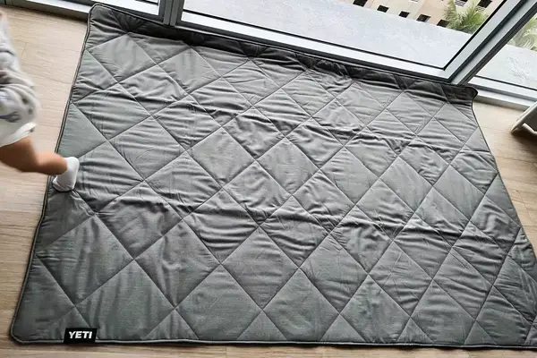 A Yeti Lowlands Blanket unfolded on a floor