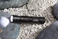 Nitecore MT21C Rechargeable Flashlight in carrying holster displayed on rocks