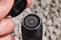 Closeup of fingers holding cap above open Nitecore MT21C Rechargeable Flashlight