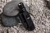 Nitecore MT21C Rechargeable Flashlight in carrying holster displayed on rocks