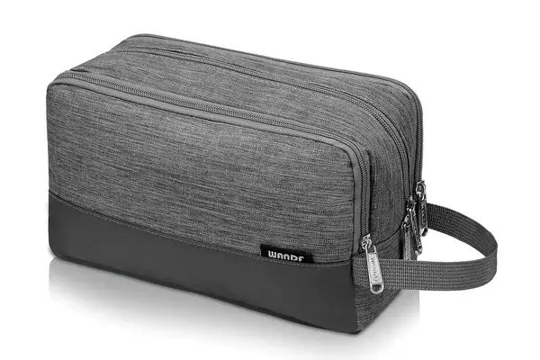 A person zipping the Thule Aion Toiletry Bag closed using a zipper