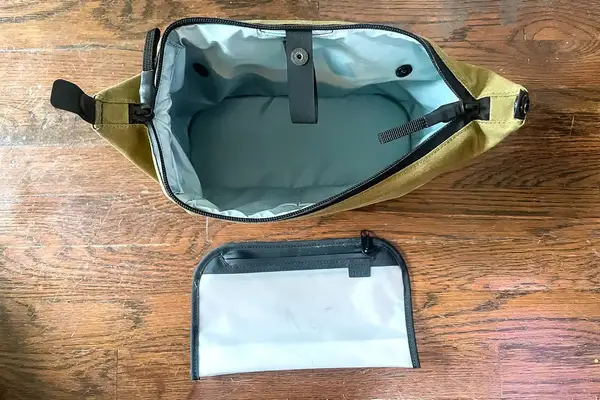 The Thule Aion Toiletry Bag open and empty with a pocket separator removed