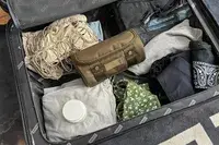 The Dagne Dover Small Seoul Dopp Kit inside a suitcase with clothing