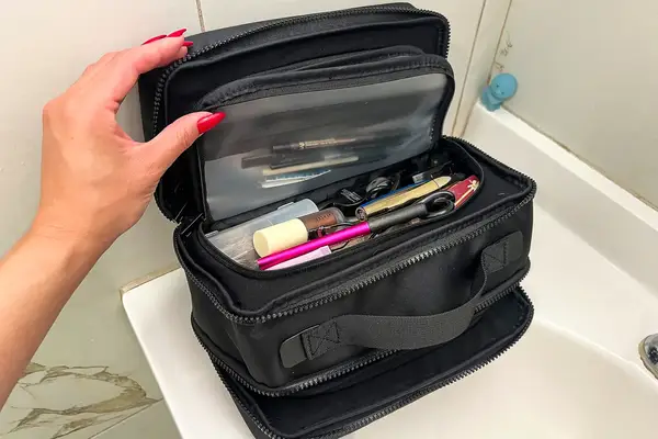A person holds the top open on the Cincha The Toiletry Bag