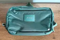 The State Hart Toiletry Kit on a wooden table