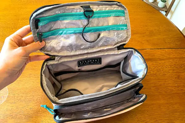 A person holds the BAGSMART Blast 4.5L Hanging Toiletry Bag open