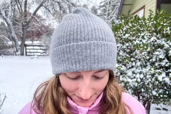 Top view of a person wearing the Quince Mongolian Cashmere Ribbed Beanie outdoors in snow