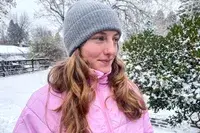 A person wearing the Quince Mongolian Cashmere Ribbed Beanie outdoors in snow