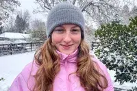 A person wearing the Quince Mongolian Cashmere Ribbed Beanie outside in the snow