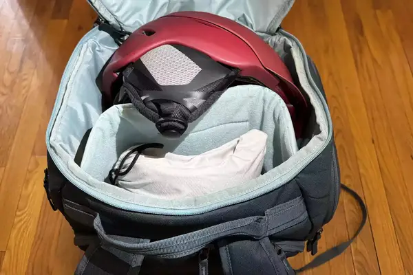 opened and packed Thule RoundTrip Snowboard and Ski Boot Backpack 60L on wood floor