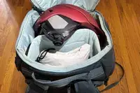 opened and packed Thule RoundTrip Snowboard and Ski Boot Backpack 60L on wood floor