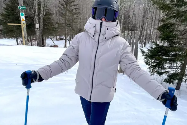 A person wearing the Aspen Collection Cirque Down Jacket outside while skiing