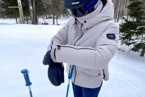 A person wearing the Aspen Collection Cirque Down Jacket outside while skiing