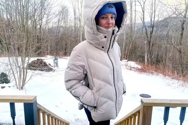 A person wearing the Aspen Collection Cirque Down Jacket with the hood on outside
