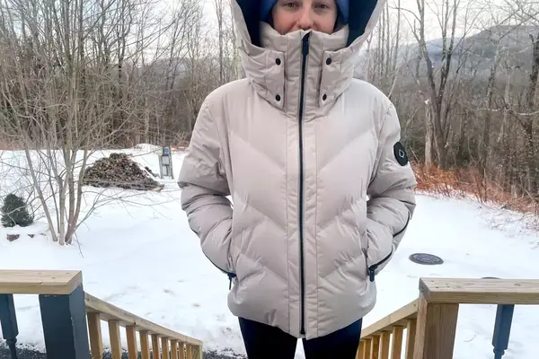 Front view of a person wearing the Aspen Collection Cirque Down Jacket outside with their hands in their pockets