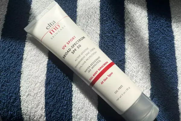 Side view of a person wearing the Aspen Collection Cirque Down Jacket while skiing 