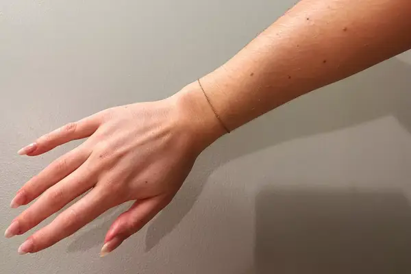 A person wearing the Aspen Collection Cirque Down Jacket with the hood on outside