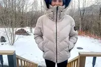 Front view of a person wearing the Aspen Collection Cirque Down Jacket outside with their hands in their pockets