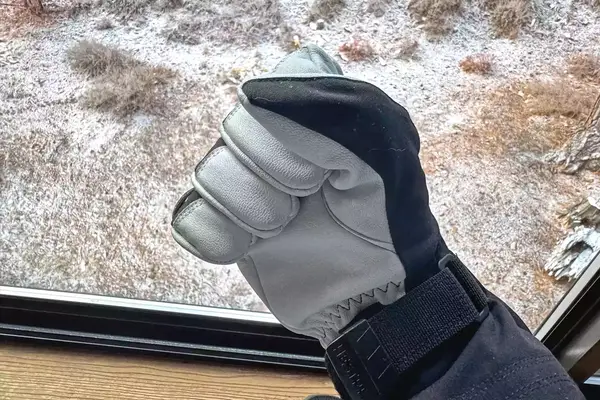 A person makes a fist while wearing the Hestra Army Leather Heli Ski Gloves