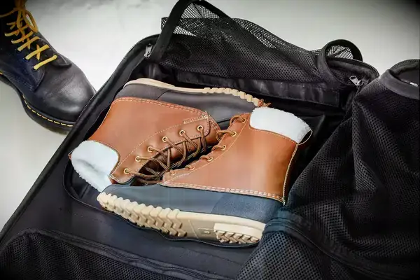 A person weighs the Away The Outdoor Rolling Duffel 85L