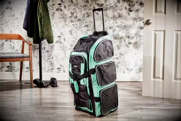 A person weighs the Away The Outdoor Rolling Duffel 85L