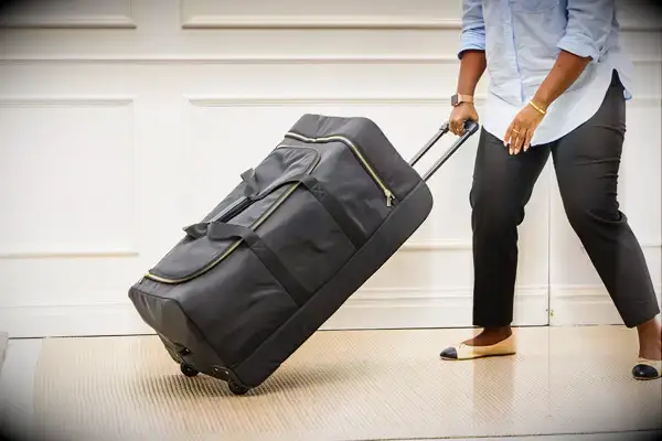 Person smacking Travelers Club Xpedition Multi-pocket Upright Rolling Duffel Bag with baseball bat 