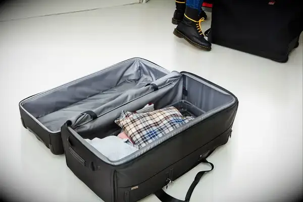 Tumi Alpha 3 Large Split 2-Wheeled Duffel on floor partially packed with clothing