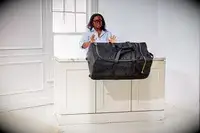 Person wheeling Tumi Alpha 3 Large Split 2-Wheeled Duffel onto pavers