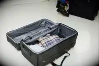 Tumi Alpha 3 Large Split 2-Wheeled Duffel on floor partially packed with clothing