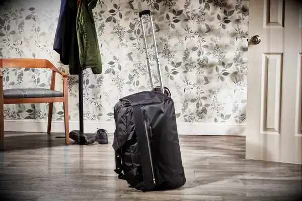 Person hitting a Tumi Alpha 3 Large Split 2-Wheeled Duffel with baseball bat